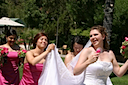 Jen carrying Rebbeca's train as she gets ready. Notice the tiny fans, it was hot that day. That is Aditi behind Jen.