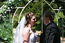 Just after the ceremony the bride and groom have a moment to reflect under a flower covered arch.